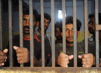 Indian fishermen stand in a police locku