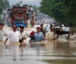 Residents carry their belongings through a flooded road in Risalpur in Pakistan's Northwest Frontier Province