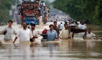 Residents carry their belongings through a flooded road in Risalpur in Pakistan's Northwest Frontier Province